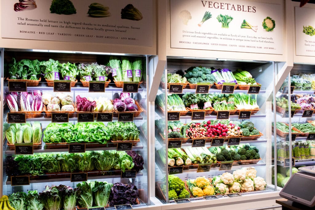 A wall of shelves filled with fresh produce at EATALY in Toronto.
