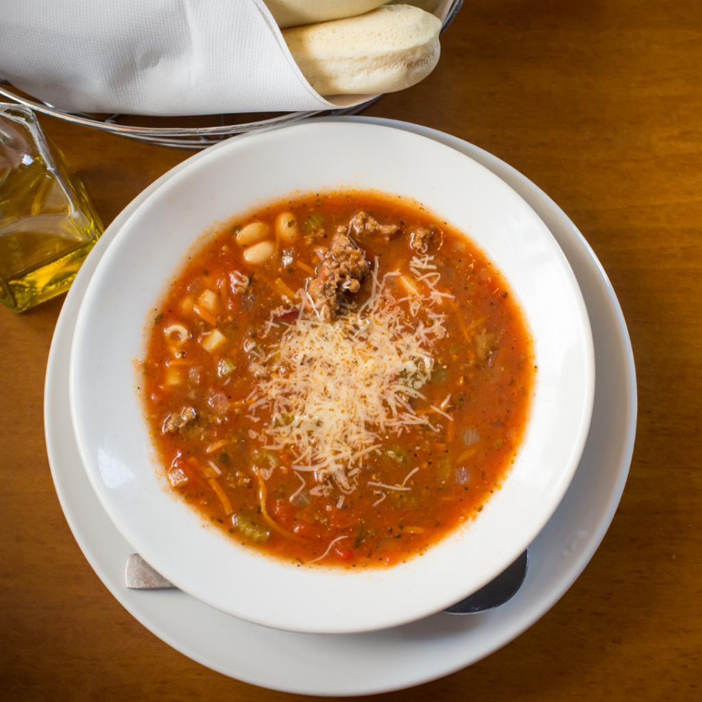 In this image is a bowl full of pasta fagioli. This is a canning preserve example of food from this piece.